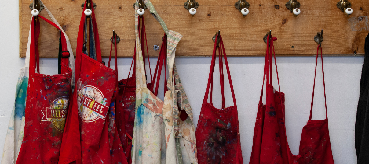 Lillstreet aprons hanging in a row in the Painting Studio