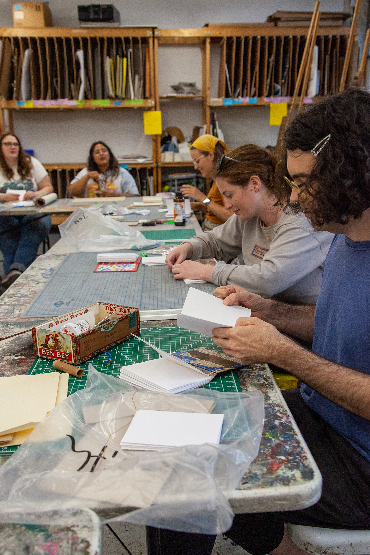 A group of students work on bookbinding projects together.