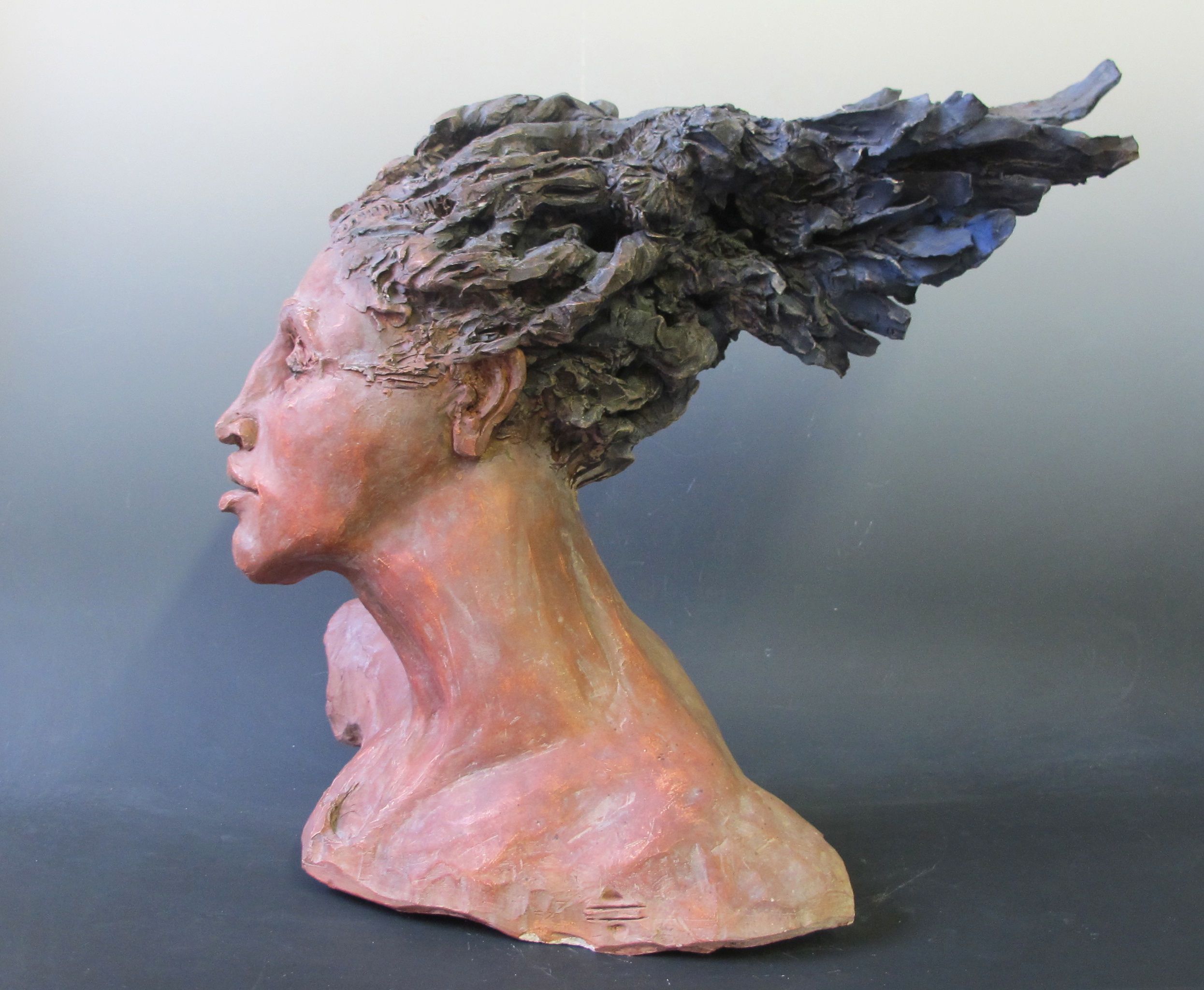 Ceramic bust, facing left, black hair blowing back.